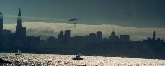 A low pass in front of the city with late afternoon fog behind the downtown skyscrapers